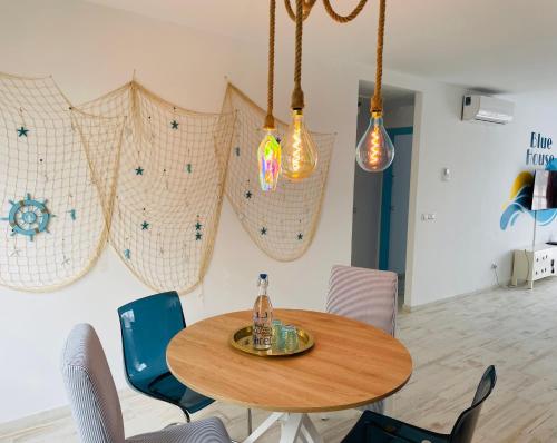 a dining room table with chairs and lights on the wall at Blue House Mallorca in Ses Salines