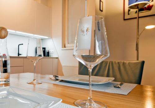 two wine glasses sitting on top of a wooden table at CitySuite Lienz in Lienz