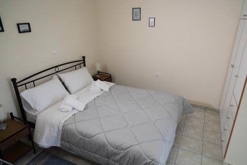 1 dormitorio con 1 cama con 2 toallas en Flo's Apartments, en Mesolongi