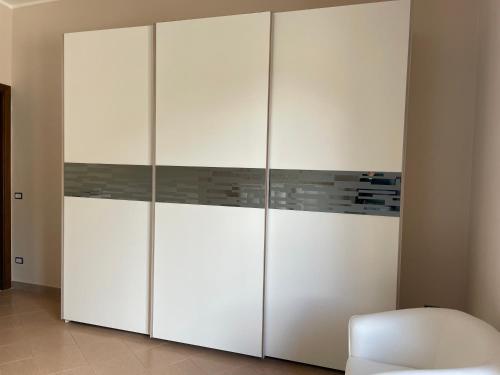 a large white closet with a white chair in a room at Prima Perla in Vietri sul Mare