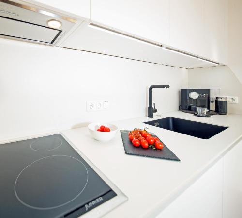 a kitchen with a counter with tomatoes on a cutting board at CitySuite Lienz in Lienz