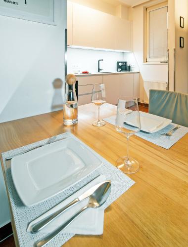a table with a plate and two wine glasses on it at CitySuite Lienz in Lienz