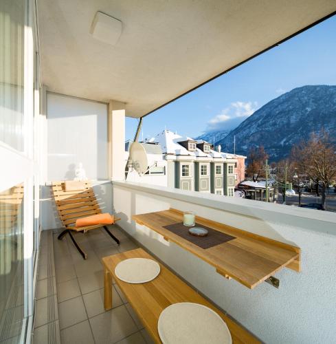 a balcony with a table and a bench on it at CitySuite Lienz in Lienz