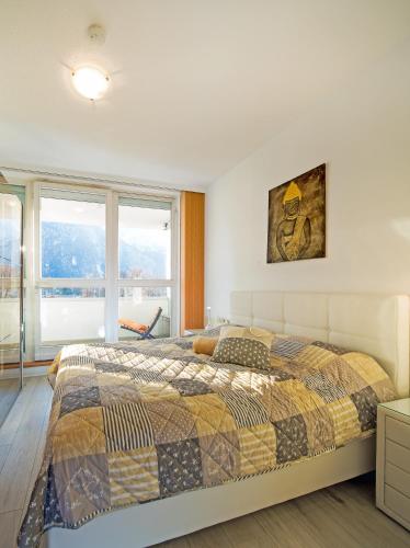 a bedroom with a bed and a large window at CitySuite Lienz in Lienz