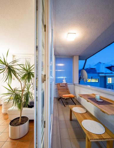 a balcony with benches and a table and a plant at CitySuite Lienz in Lienz