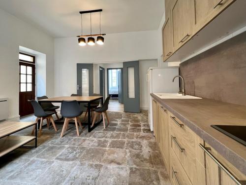 a kitchen and dining room with a table and chairs at Chai Merlot in Saint-Cyprien