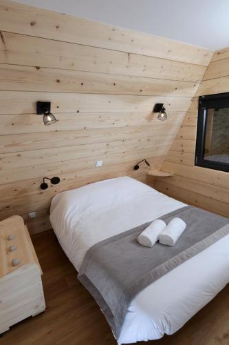 une chambre avec un lit dans un mur en bois dans l'établissement Ô TIPI LODGE, à Saint-Christo-en-Jarez