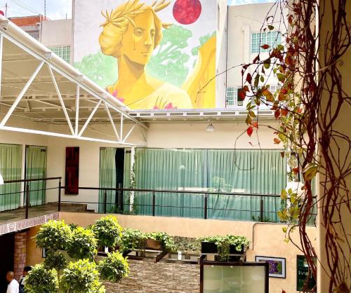 a large mural on the side of a building with plants at Downtown Treasure Place in Mexico City