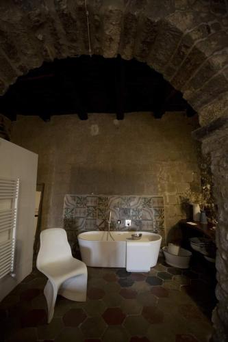 a bathroom with a tub and a sink and a chair at Casa Aulivo in Caiazzo