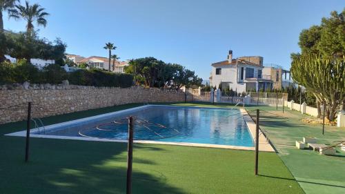 a swimming pool with a basketball hoop in a yard at La casita de la playa in Gran Alacant