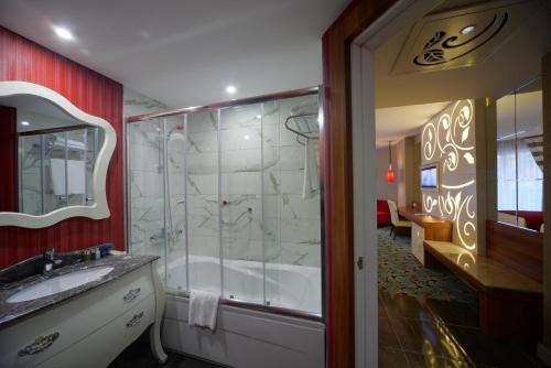 a bathroom with a shower and a sink at Vikingen Infinity Resort & Spa in Avsallar