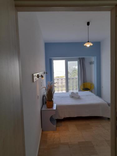 a bedroom with a white bed and a window at Avra Studios in Masouri