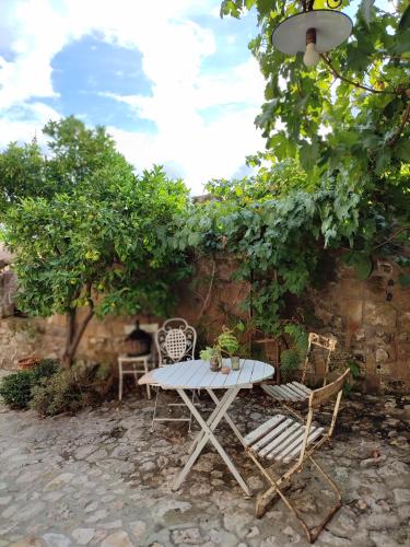 a table and chairs in front of a wall at Casa Aulivo in Caiazzo