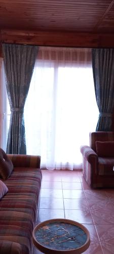 a living room with a couch and a table at Rosemary Pansiyon in Cıralı