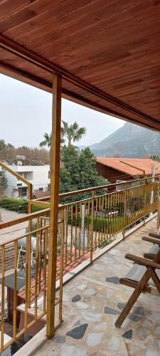 a wooden deck with chairs and a view of the ocean at Rosemary Pansiyon in Cıralı