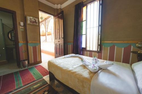 a bedroom with a bed with a bow on it at Villa Nile House Luxor in Luxor