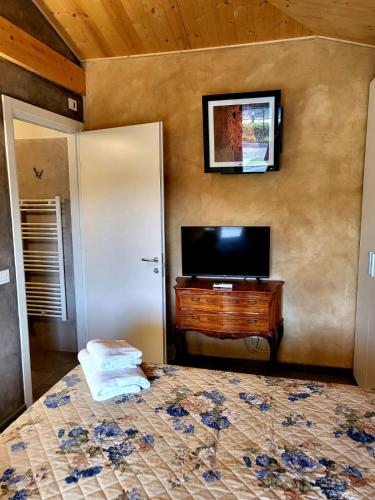 a bedroom with a bed and a flat screen tv at Villa Torricelli Scarperia - Il Giardinetto Residence in Scarperia