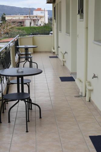 a balcony with tables and chairs on a building at Flo's Apartments in Mesolongion