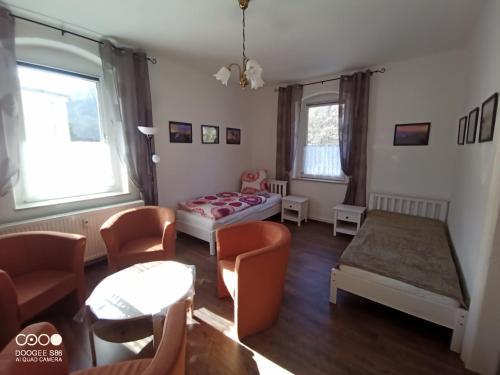 uma sala de estar com uma cama, uma mesa e cadeiras em Ferienwohnungen Familie Winter em Dohna