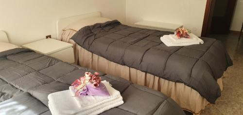 two beds in a room with towels and dolls on them at Apartments Delise in Scardovari