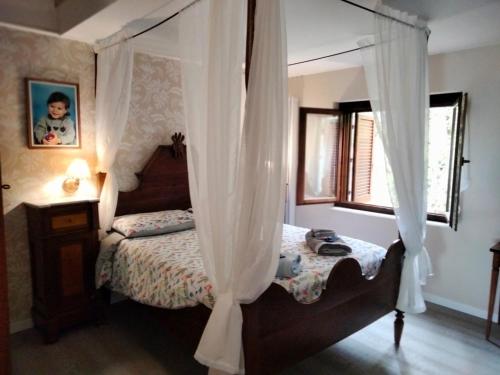 a bedroom with a canopy bed and a window at Sguardo sul lago in Trevignano Romano