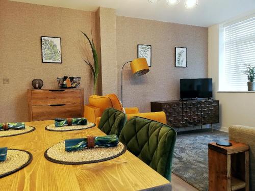 - un salon avec une table, des chaises et une télévision dans l'établissement Executive Apartment nr NEC, BHX, Resorts World, à Hampton in Arden