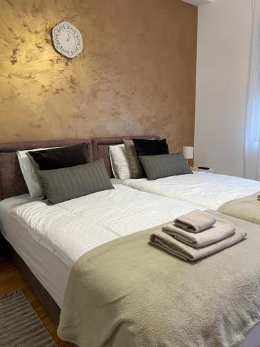 twee bedden met handdoeken in een slaapkamer bij Apartman studio Lusi in Subotica