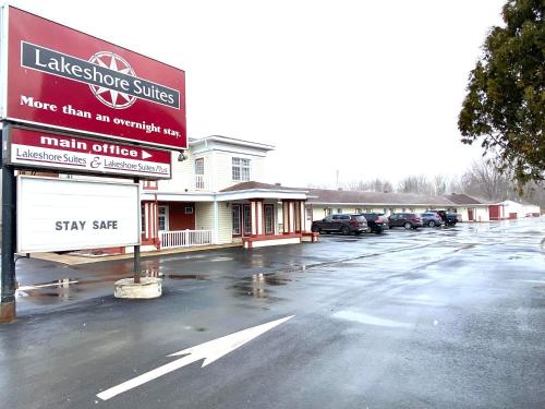 a parking lot in front of a small store at Lakeshore Suites in North Bay