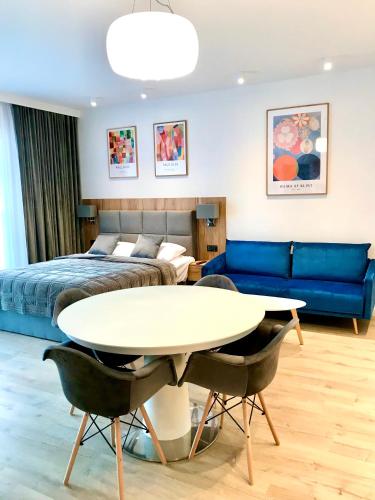 ein Schlafzimmer mit einem Bett, einem Tisch und einem Sofa in der Unterkunft Apartament Rodzinny Z Dużym Tarasem in Pogorzelica