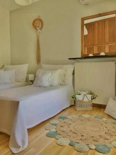 a bedroom with a large white bed and a rug at Villa Persephone in Megali Ammos