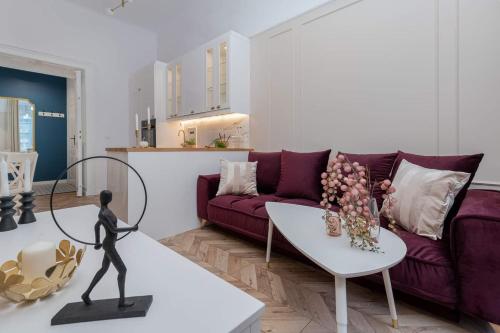 ein Wohnzimmer mit einem lila Sofa und einem Tisch in der Unterkunft Olver Apartment in Krakau