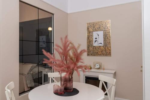 une salle à manger avec une table et un vase avec une plante dans l'établissement Olver Apartment, à Cracovie