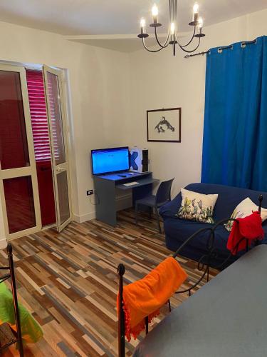 a living room with a blue couch and a desk at La casa di Gioggiò in Ioppolo Giancaxio