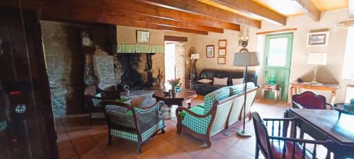a living room with a couch and chairs and a table at Longère briéronne 15 mn de La Baule in Saint-Lyphard