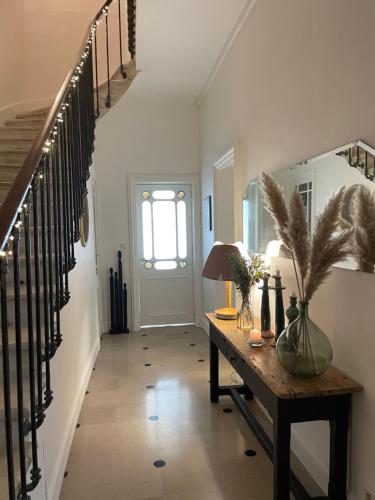 a hallway with a table and stairs with a window at Chambres d'hôtes - La Maison 19 in Niort