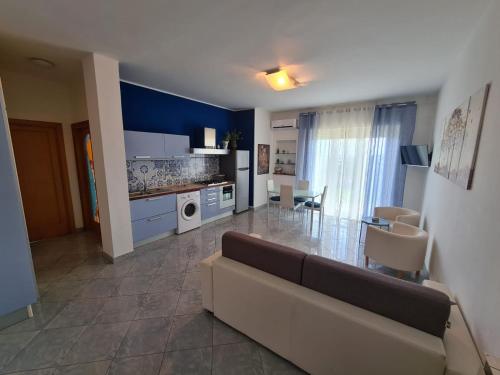 a large living room with a couch and a kitchen at La pioggia nel pineto in Gaeta