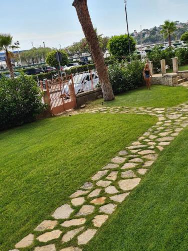 a woman walking down a stone path in a park at La pioggia nel pineto in Gaeta