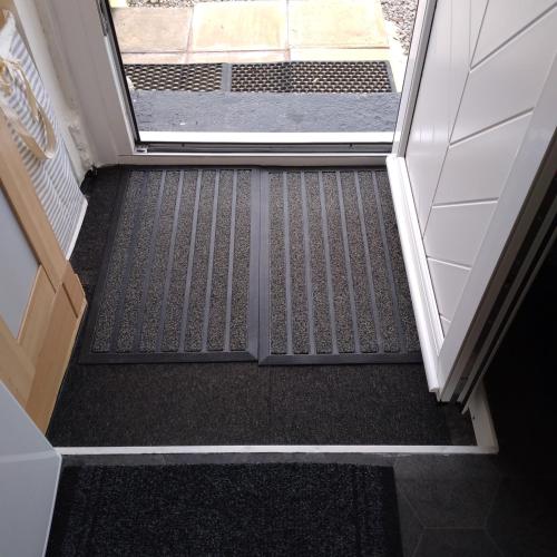 an open door with a black carpeted floor in a hallway at Kims Retreat in Caernarfon