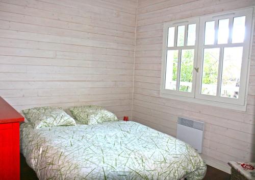 une chambre avec un lit et une fenêtre dans l'établissement La Villa Coloniale, à Lacanau-Océan