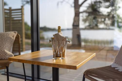 Käringsund Resort في إكيرو: طاولة مع زجاجة نبيذ وأكواب عليها