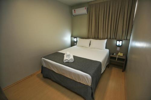 Essência Hotel Pato Branco tesisinde bir odada yatak veya yataklar