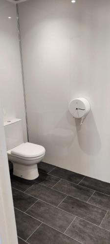 a white bathroom with a toilet and a tile floor at Ashiana in Newark upon Trent