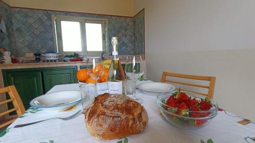 a table with a loaf of bread and a bowl of fruit at La Casa Dei Delfini in Lampedusa
