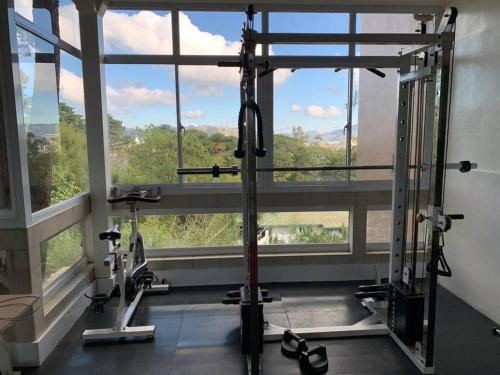 Un gimnasio con dos máquinas de correr frente a una ventana. en Grandview 312 - 1BR Condo Near Burnham Park, en Baguio