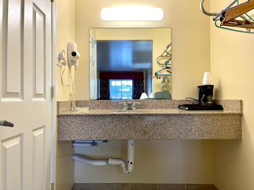 uma casa de banho com um lavatório e um espelho em Passport Inn Somers Point - Somers Point em Somers Point