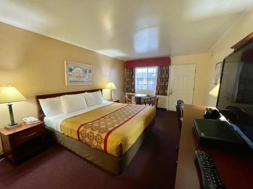 um quarto de hotel com uma cama grande e uma secretária em Passport Inn Somers Point - Somers Point em Somers Point
