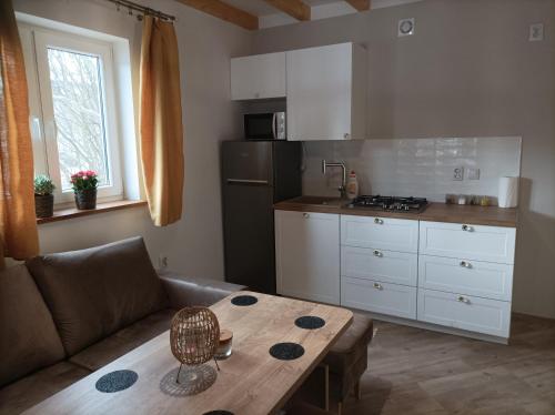 uma cozinha com um sofá e uma mesa num quarto em Noclegi Różanka em Radomierz