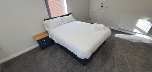a bed with white sheets and pillows in a room at APARTMENT in BARNSLEY CENTRAL in Barnsley