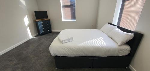 a bedroom with a bed with white sheets and pillows at APARTMENT in BARNSLEY CENTRAL in Barnsley