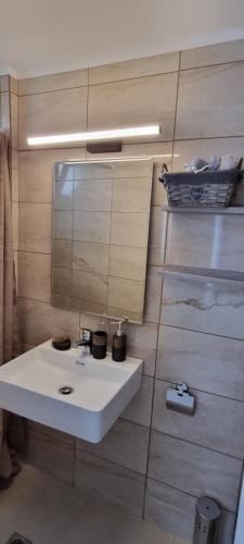 a bathroom with a white sink and a mirror at Secret Garden Hotel in Maleme